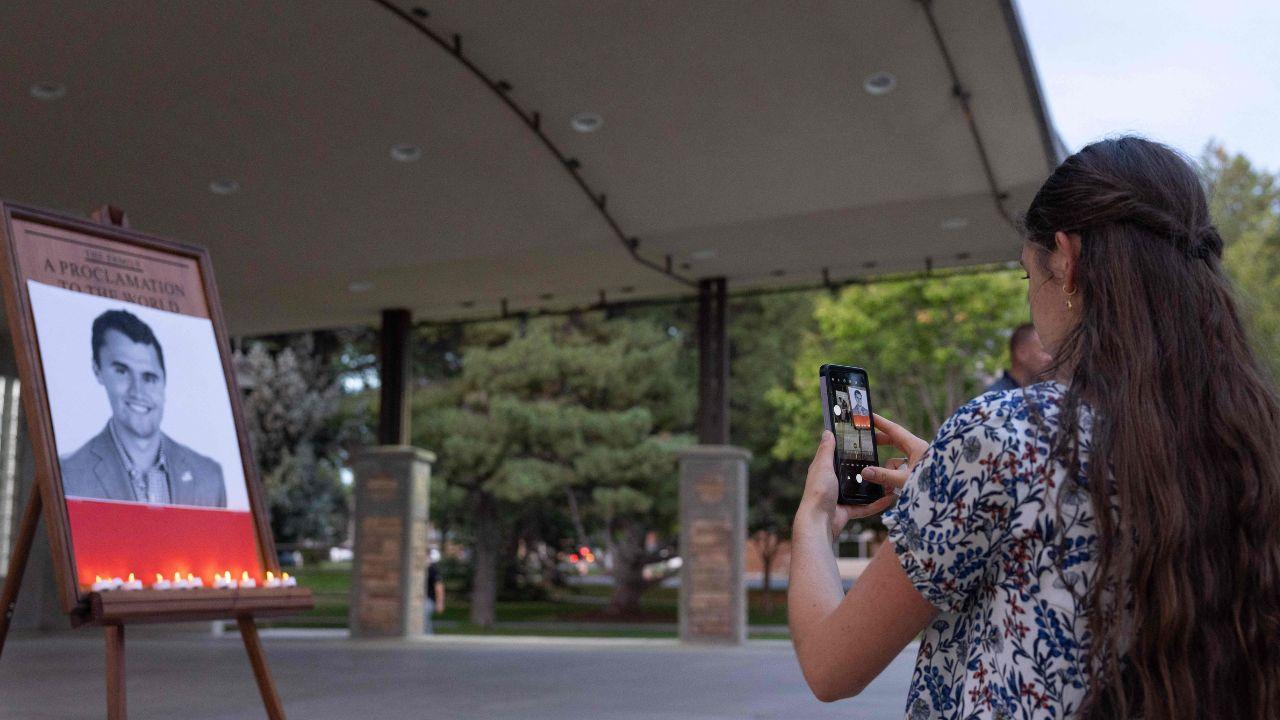 A girl takes a picture of youth activist and influencer Charlie Kirk's memorial photo